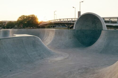 Rå betonskatepark ved en bro i varmt aftensolskin