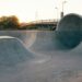 Rå betonskatepark ved en bro i varmt aftensolskin