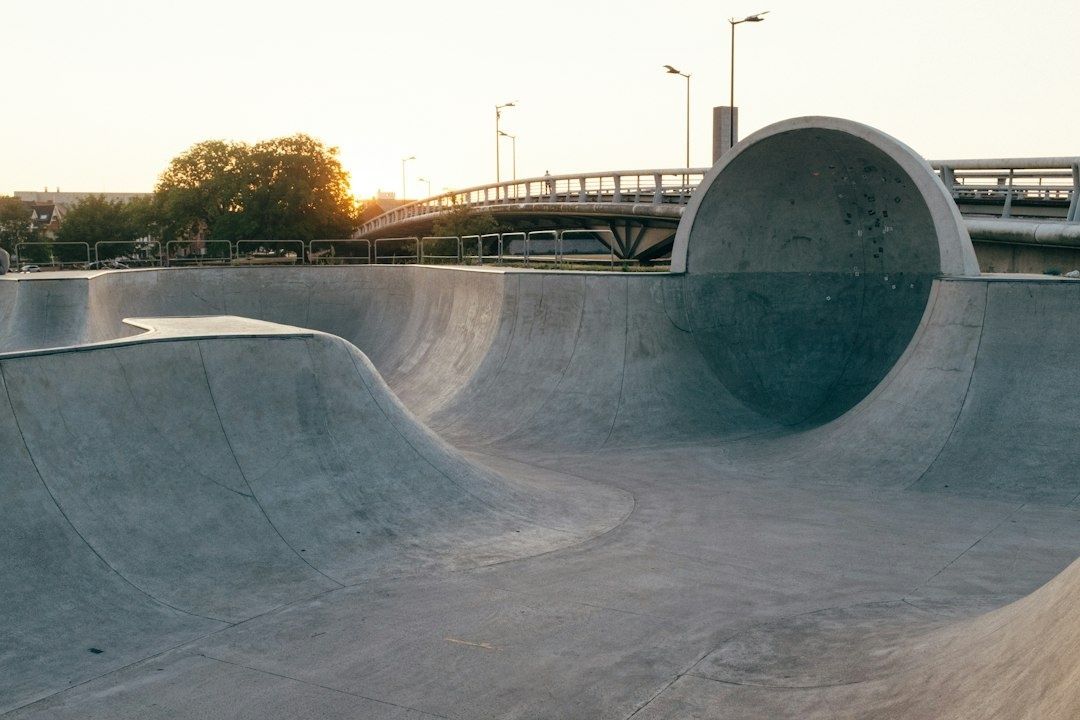 Rå betonskatepark ved en bro i varmt aftensolskin